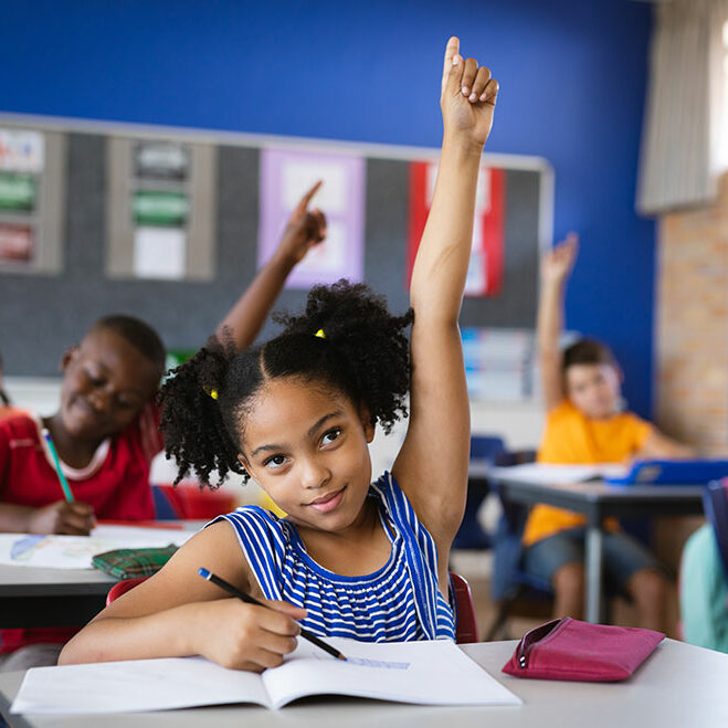 african american student in a classroom raising their hand